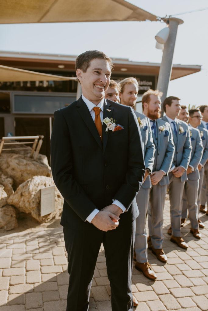 A groom becomes emotional when he sees his bride at the end of the aisle at The Ocean Institute in Dana Point