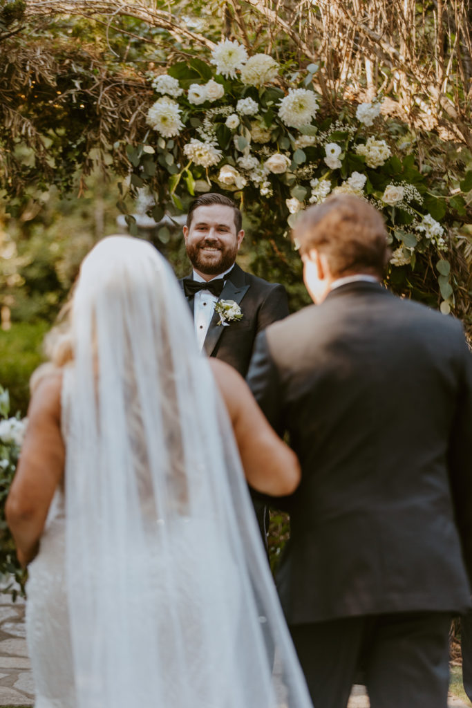 A groom seeing his bride for the first time as she walks down the aisle on their wedding day.